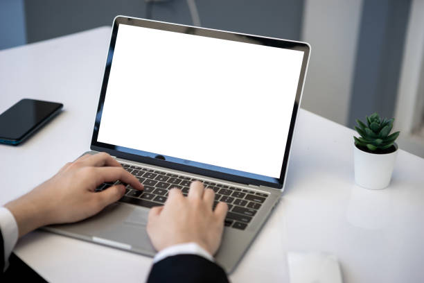 istock Asian business man dringking coffee wearing suit, enjoying watching educational webinar on laptop or laptop and smartphone. Smiling with chat and holding video call with clients partners. 1306248077