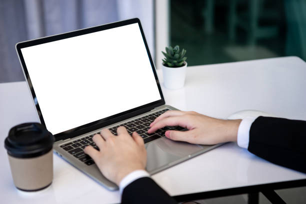 istock Asian business man dringking coffee wearing suit, enjoying watching educational webinar on laptop or laptop and smartphone. Smiling with chat and holding video call with clients partners. 1306248105