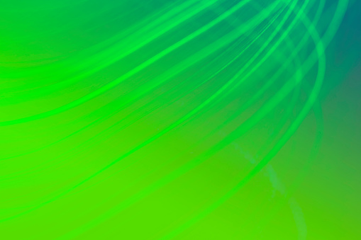 Abstract background with motion blurred lines in green tones. Made by fiber optics in motion.