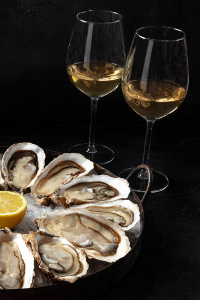 istock Raw oysters on a platter with glasses of white wine 1306250070