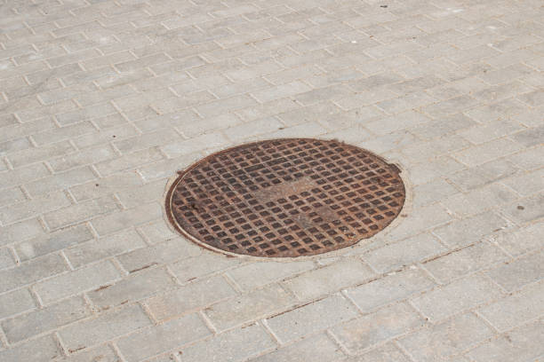 istock Manhole cover on the sidewalk close up 1306250891