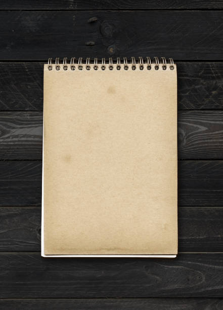 istock Closed spiral Note book on a black wood table 1306251676