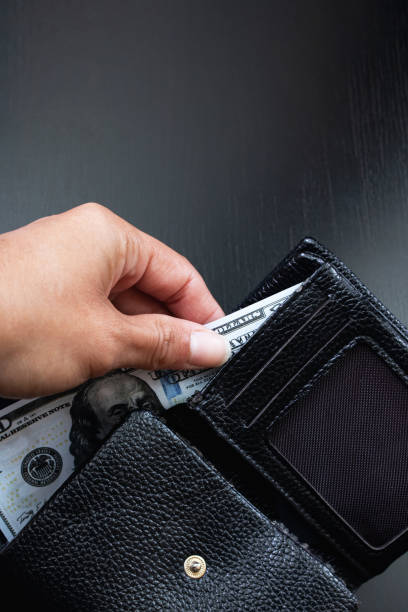 istock One hundred dollar bill in black wallet in hand 1306251926