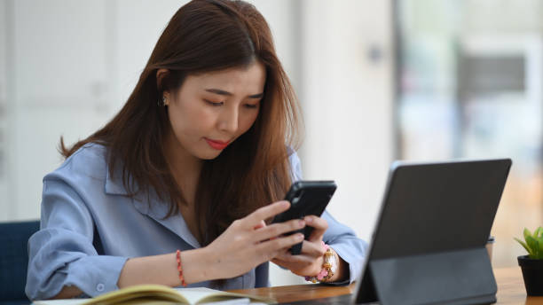 istock Young woman working with computer tablet and using mobile phone at office. 1306252801