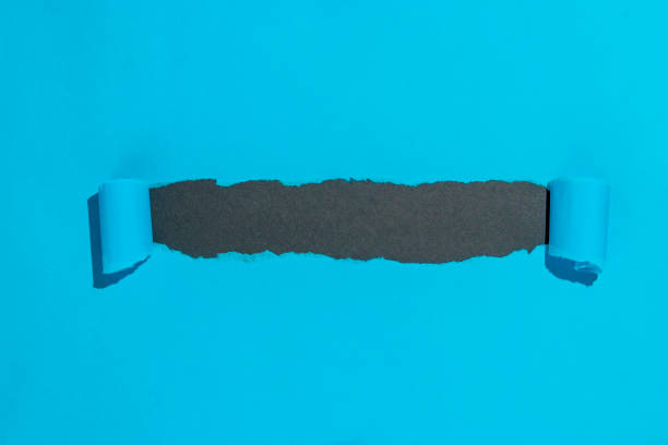 istock Blue paper opened ripped to reveal black copy space 1306253055