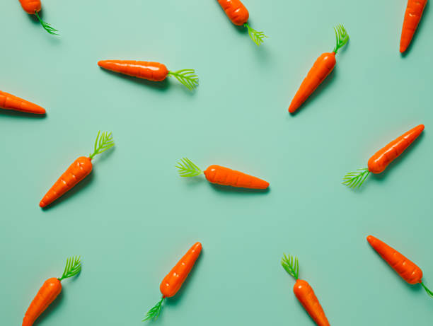 istock Pattern made with miniature baby carrots on pastel green background 1306254709