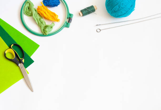istock Creativity and needlework flat lay, scissors, skein of knitting thread, knitting needles, felt, spool of thread with needle and embroidery frame, copy space 1306254787