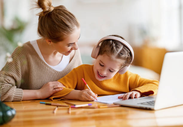 madre felice che sostiene la figlia durante gli studi online - 16330 foto e immagini stock