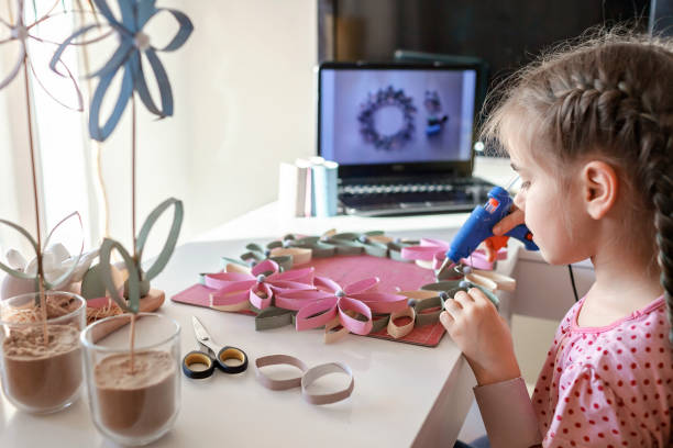 istock Girl doing wreath with toilet roll tube via online master class, zero waste Easter celebration 1306260289