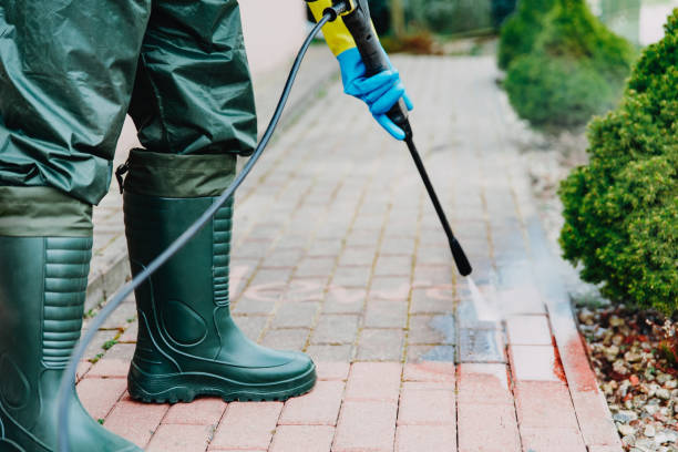 Man cleaning red, conrete pavement block using high pressure water cleaner. Paving cleaning concept Man cleaning red, conrete pavement block using high pressure water cleaner. High pressure cleaning. Man wearing waders, protective, waterproof trousers and gloves doing spring jobs outdoors. Pressure Washers stock pictures, royalty-free photos & images