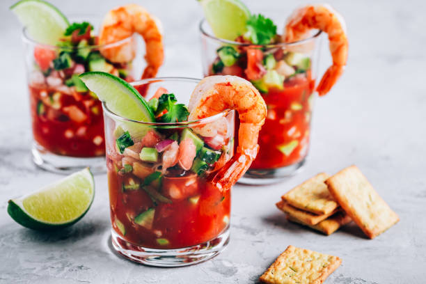 refreshing mexican shrimp cocktail with lime in glass on gray stone background - cocktail avocado imagens e fotografias de stock