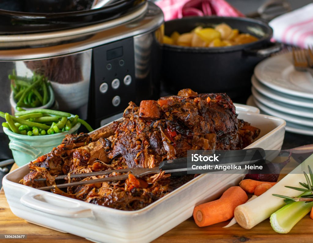 Slow cooker dish with roast pork fresh and homemade slow cooked roast pork in a slow cooker with root vegetables. Ready to eat meal Crock Pot Stock Photo