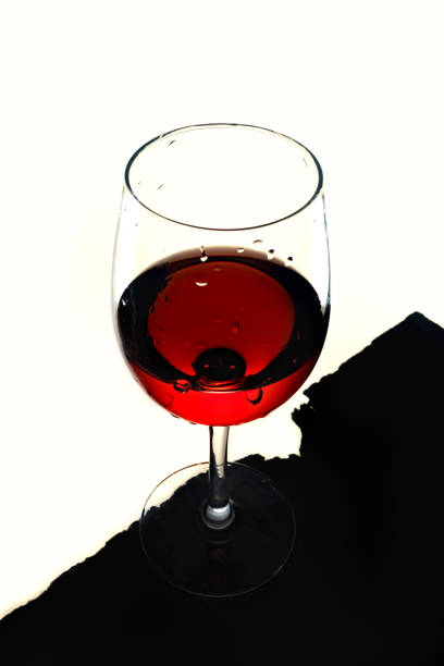 istock Red wine in a glass on a white background on a dark old board 1306266386