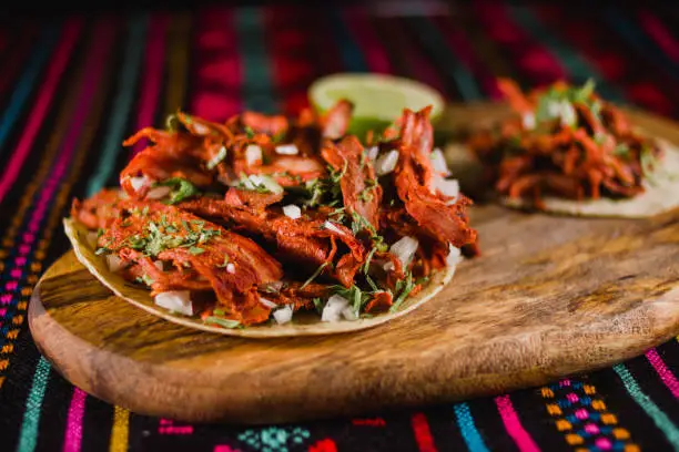 Photo of Mexican tacos al pastor on a ethnic pattern