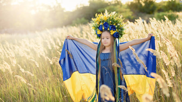 menina carrega bandeira azul e amarela e vibração da ucrânia no campo. - parade flag child patriotism - fotografias e filmes do acervo