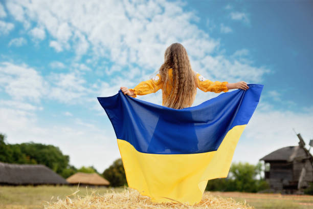 menina carrega bandeira azul e amarela e vibração da ucrânia no campo. - parade flag child patriotism - fotografias e filmes do acervo