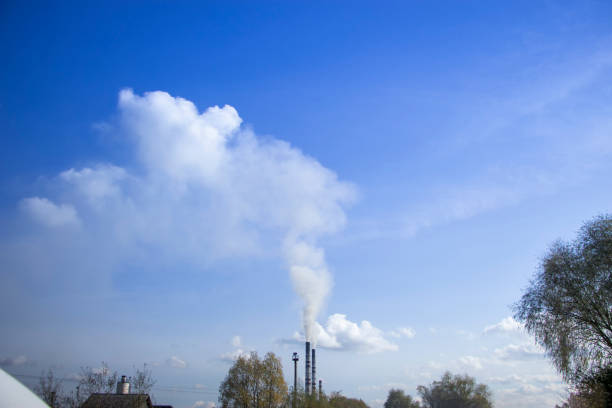 Smoke from a chimney in the blue sky.
