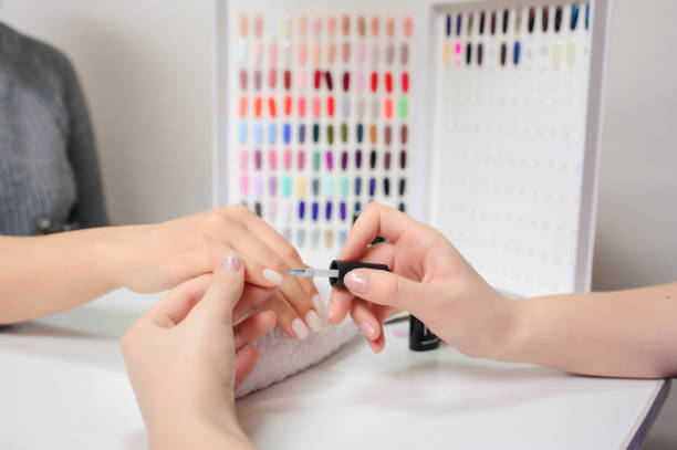 istock Manicurist is applying nail polish on a client's nail. 1306277844