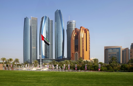Abu Dhabi, United Arab Emirates, March 31, 2018: View of the iconic skyscrapers including Etihad Towers with the flag of the United Arab Emirates.
