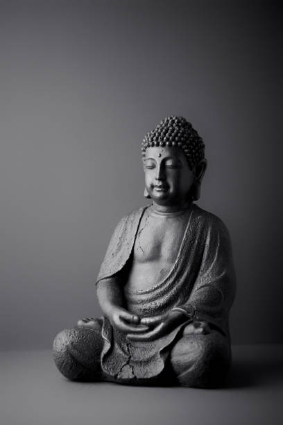 istock Meditating Buddha Statue on paper background. Copy space. 1306280464