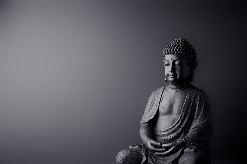 Meditando estatua de Buda sobre fondo de papel. Copiar espacio. photo