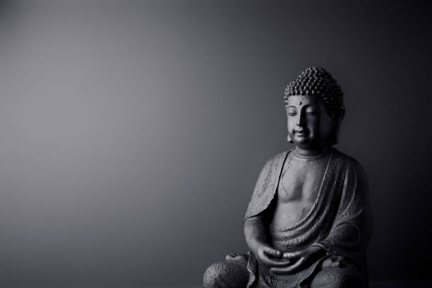 meditating buddha statue on paper background. copy space. - buda imagens e fotografias de stock