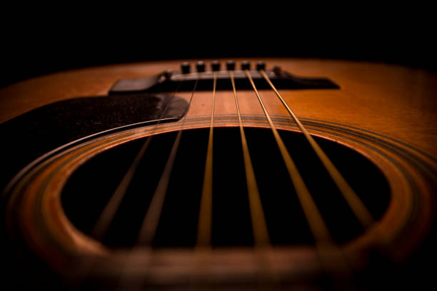 acordes de guitar.guitar. guitarra acústica. music.music fondo. imagen de una guitarra acústica en la oscuridad. tocando música con unos amigos en la oscuridad. música clásica. primer plano de la guitarra - musical instrument string music dark old fashioned fotografías e imágenes de stock