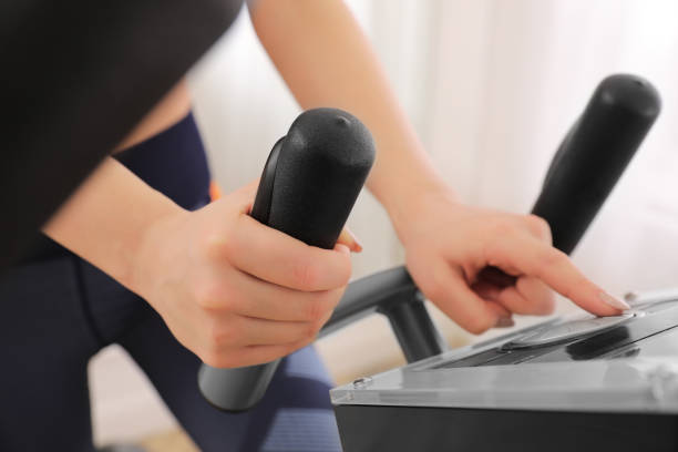 istock Woman using modern elliptical machine indoors, closeup 1306284975
