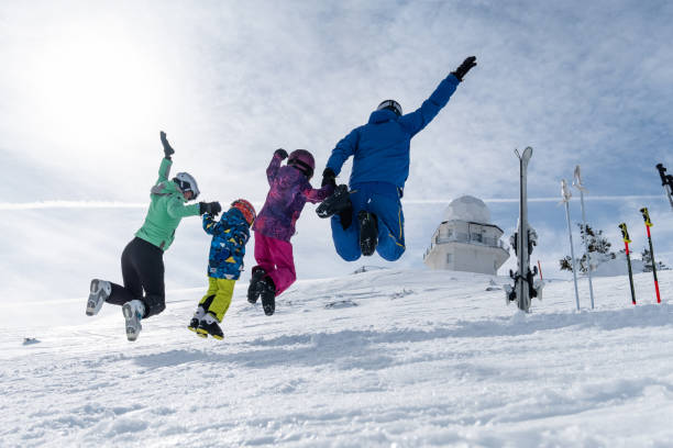 istock Happy ski family having fun jumping on the snow 1306288086