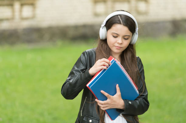 studentessa che ascolta audiolibri sulla strada per la scuola, concetto di apprendimento facile - one kid only audio foto e immagini stock