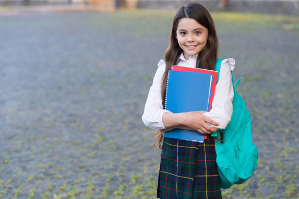 istock Little girl formal style uniform and backpack hold books, school schedule concept 1306288165