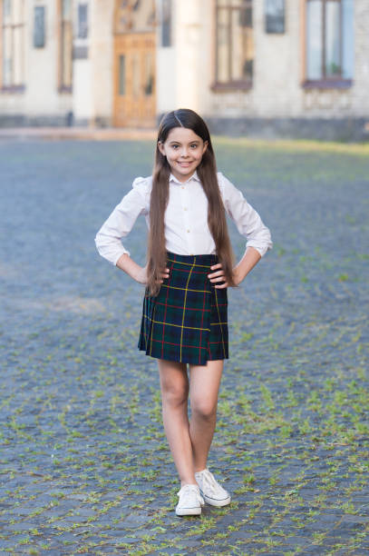 istock Little girl formal style uniform in school yard, knowledge day concept 1306288378