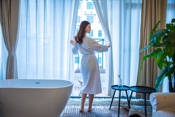 istock Young woman opening curtains 1306289490