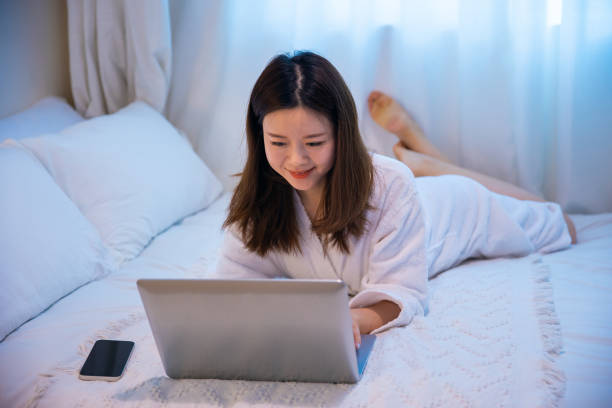 istock Young woman working with laptop on bed 1306289631