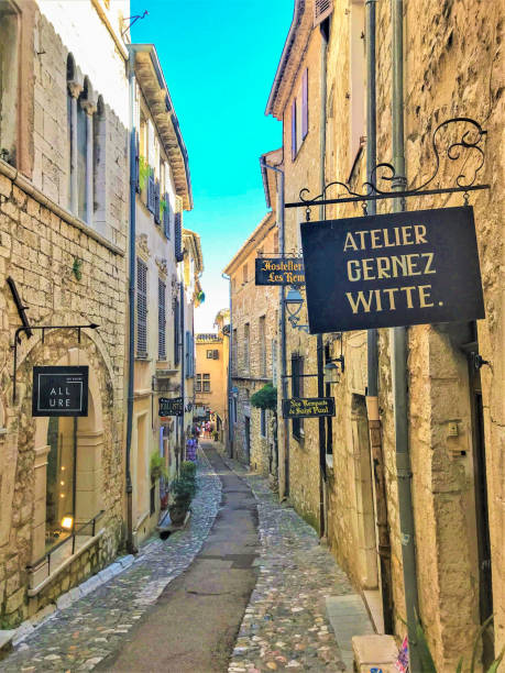 Street in Saint Paul De Vence, South of France Saint-Paul-De-Vence, France - July 17 2018: a street lined with ateliers in the medieval town in Cote d'Azur. biot stock pictures, royalty-free photos & images