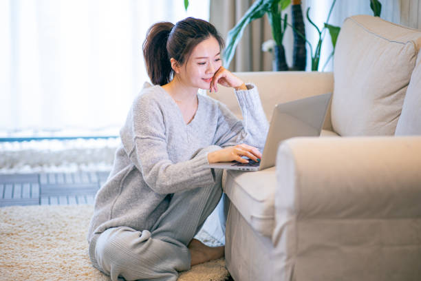 istock Young woman using laptop at home 1306292138