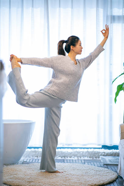 istock Young woman practicing yoga at home 1306292160
