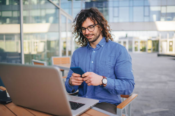 istock Handsome businessman woth curly hair using the mobile phone 1306294226