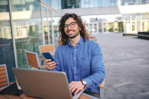 istock Handsome businessman woth curly hair using the mobile phone 1306295147