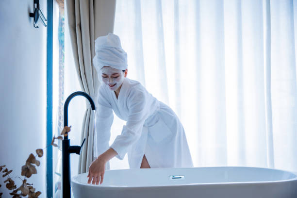 istock Young woman touching foam water before taking bath 1306295160