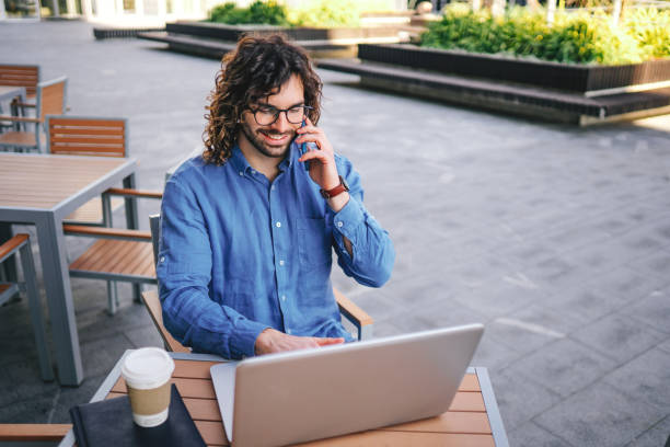 istock Handsome businessman with curly hair  is working outside 1306295180