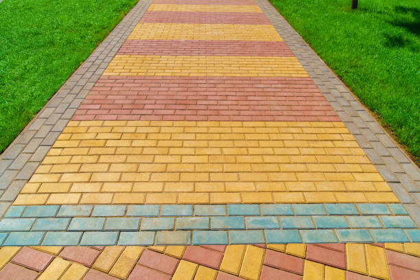 istock walkway made of paving slabs and green grass as a background, bright sunlight 1306295377
