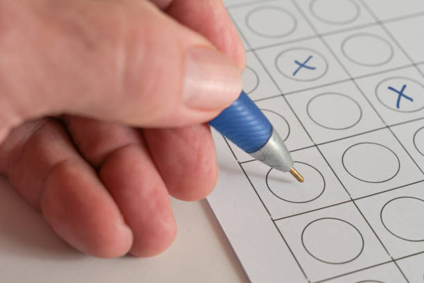 istock Hand with a blue pen making answer crosses on a paper form, concept for a business application test or voting at an election, copy space, selected focus 1306298016