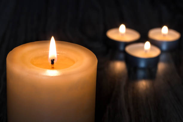 istock Tragedy. Death. Candles on a wooden background. 1306298048