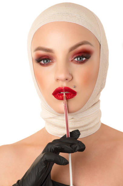 istock woman applying lip gloss isolated on white 1306299382