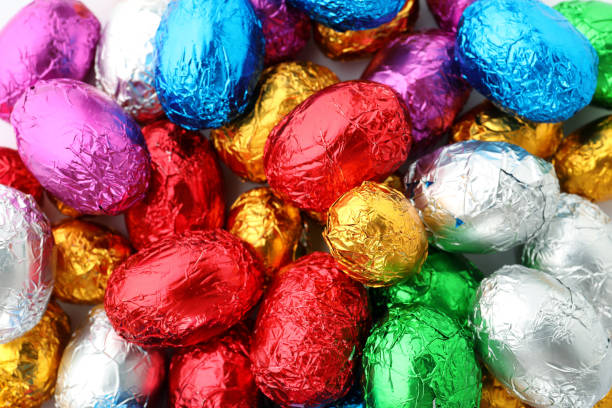 istock Many chocolate eggs wrapped in bright foil as background, top view 1306302008