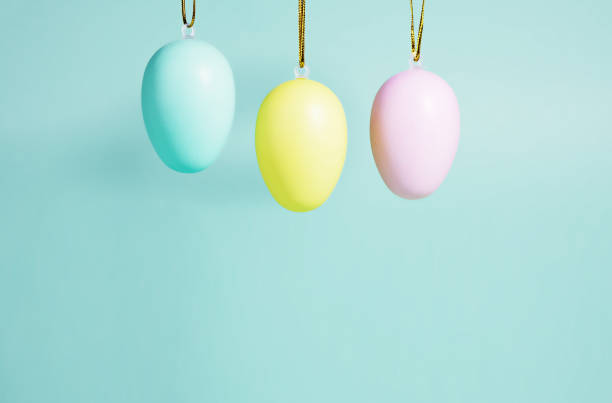 istock Easter background. A collection of Easter eggs in pastel colors hanging on a blue-green background. Easter concept 1306303132