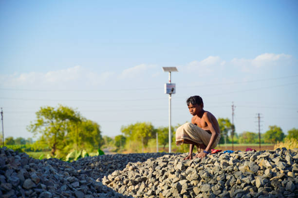 indian poor child seating on little stone pile