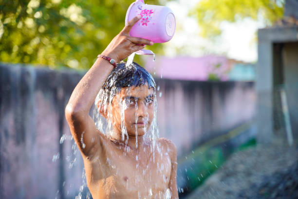 istock Cute indian poor child enjoy bathing in open place 1306307103