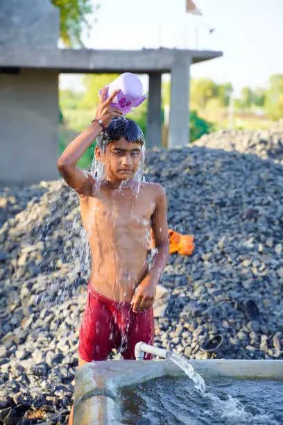Photo of Cute indian poor child enjoy bathing in open place